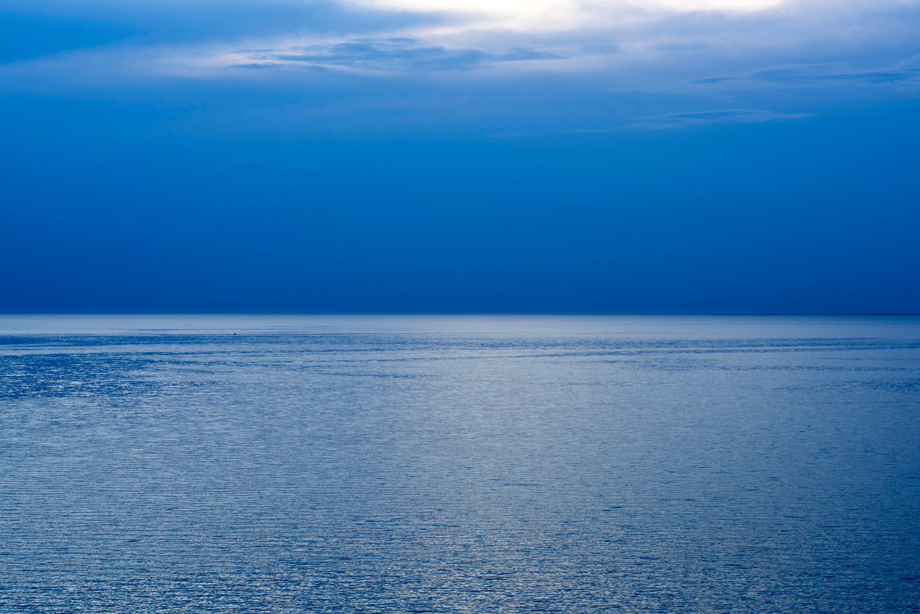 Blue ocean water extends toward the horizon beneath clouds