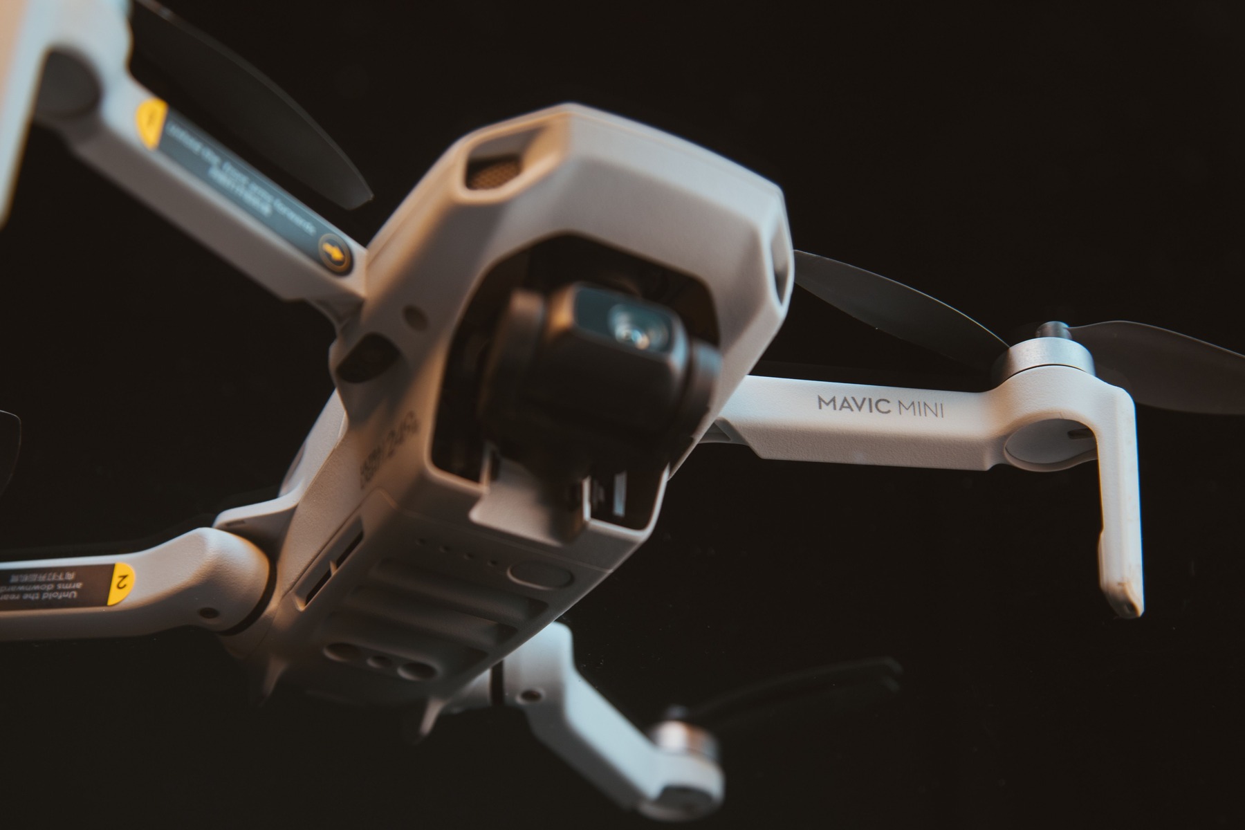 Close-up of a compact quadcopter drone hovering against a dark background