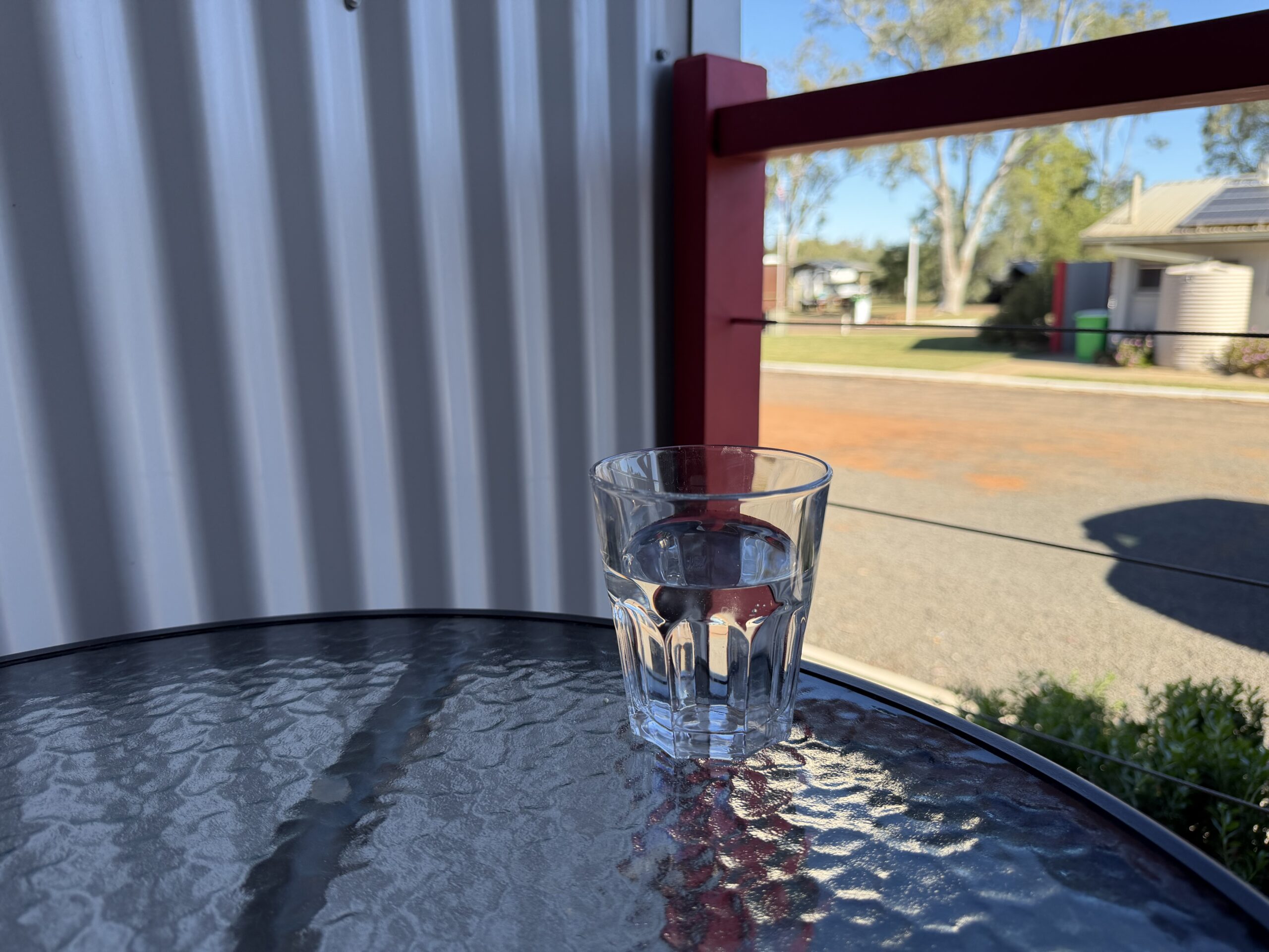 Glass of water on a table beside a window