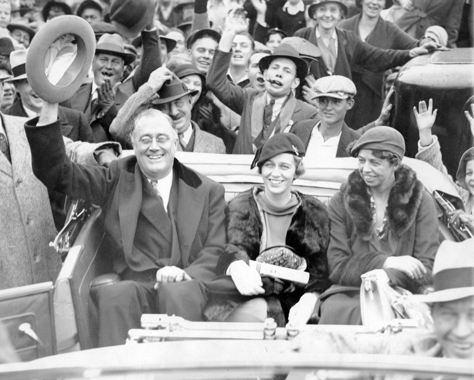 Franklin D. Roosevelt in an open car with his daughter Anna and his wife Eleanor at Warm Springs, Georgia, during the 1932 campaign, with a crowd behind